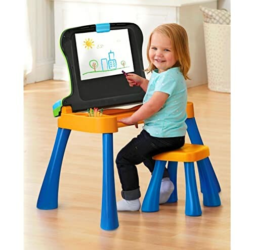 Child drawing on an easel with a small table and chair set.